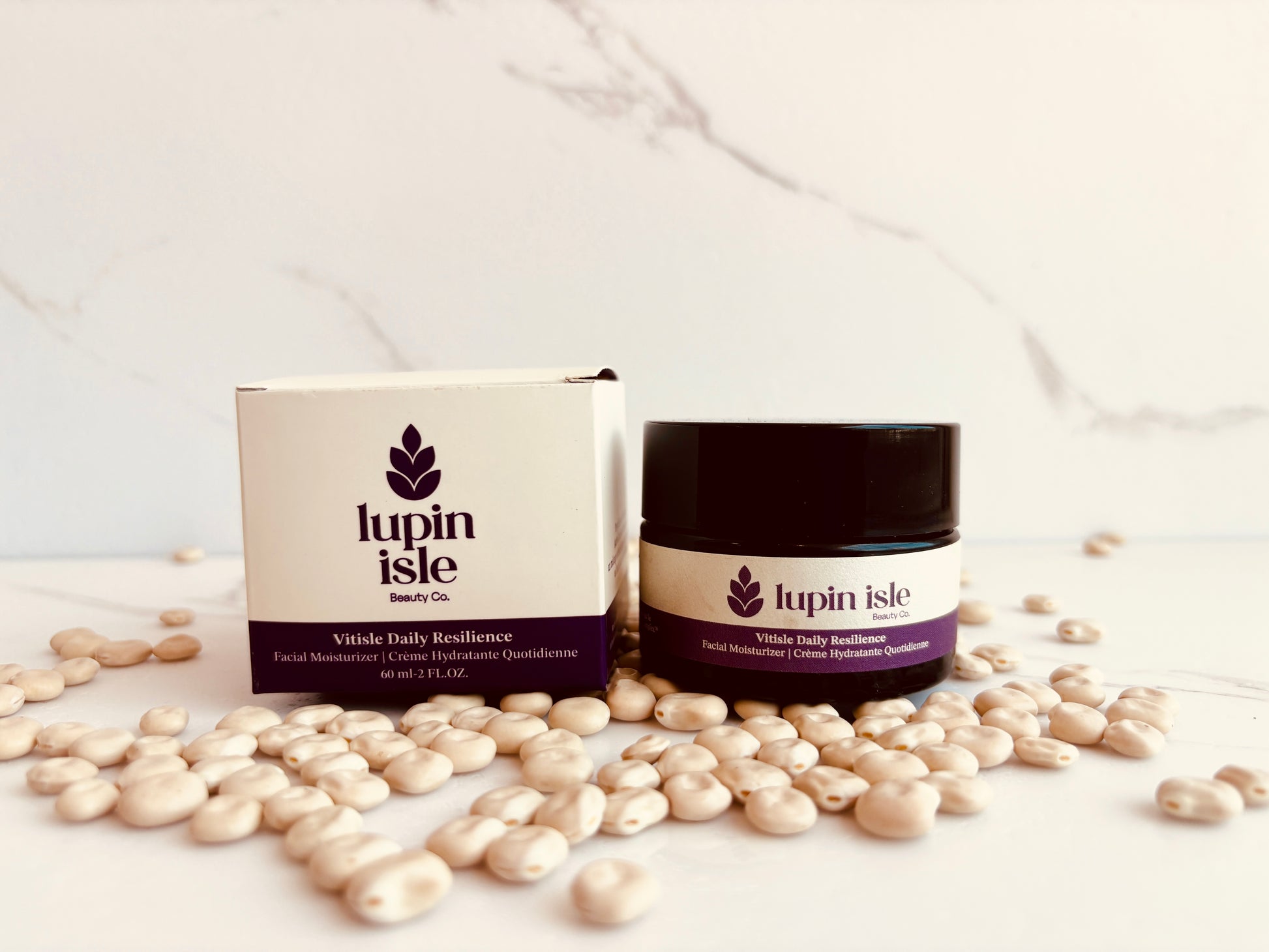 Lupin Isle Whole Daily Resilience facial moisturizer jar and its packaging box, styled with scattered white beans on a white marble surface.